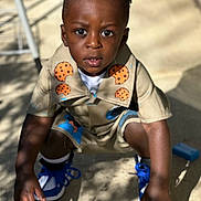 Akaiyo is registered to the contest to win money with this photo: child, boy, outdoor, squatting, curious, shorts, shirt, sneakers, blue_shoes, cookies_pattern, sunlight, shadow, expression, hair, face, skin, hands, concrete, playful, casual