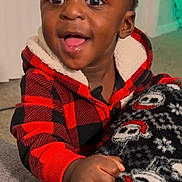 Akaiyo is registered to the contest to win money with this photo: toddler, child, smiling, hoodie, plaid, blanket, indoor, happy, face, hand, cozy, carpet, furniture, young_child, cute, expression, warm_lighting, black_hair, patterned_blanket, red