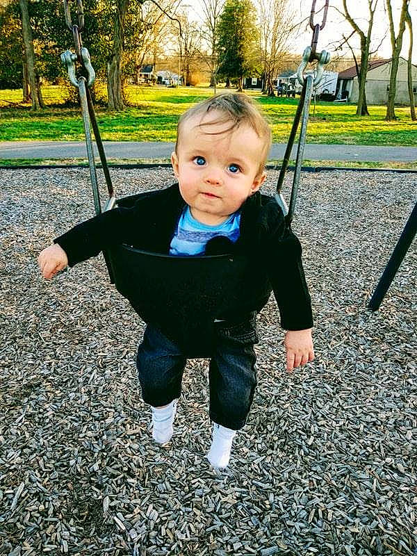 Eli Garrett is registered to the contest to win money with this photo: baby, child, fun, leaf, outdoor_play_equipment, park, person, plant, play, playground, public_space, recreation, smile, swing, toddler, tree