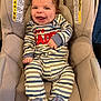 baby, infant, smiling, laughing, car_seat, seat, safety_label, warning_label, striped_clothing, onesie, booties, hands, eyes, hair, cheeks, tongue, happy, portrait, indoor, fabric