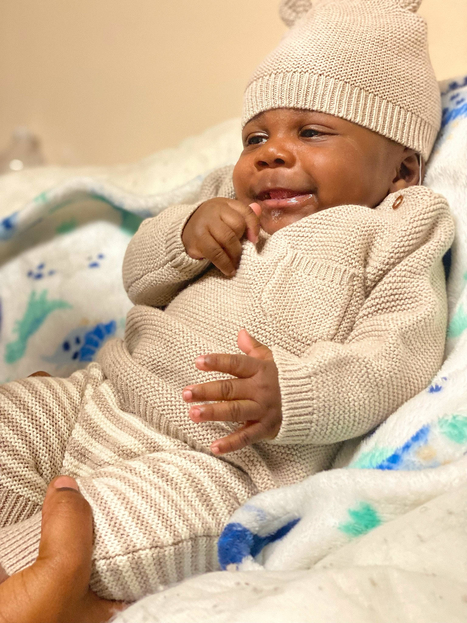 Kairo is registered to the contest to win money with this photo: baby, baby_toddler_clothing, cap, cheek, child, comfort, eye, face, finger, gesture, happy, head, headgear, headwear, human_body, linens, people, person, skin, smile