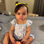 Alora is registered to the contest to win money with this photo: baby, child, girl, yellow_hair_bows, dress, shoes, bed, bedroom, curly_hair, sitting, indoors, cute, infant, person, furniture, soft_lighting, portrait, young_child, human, apparel