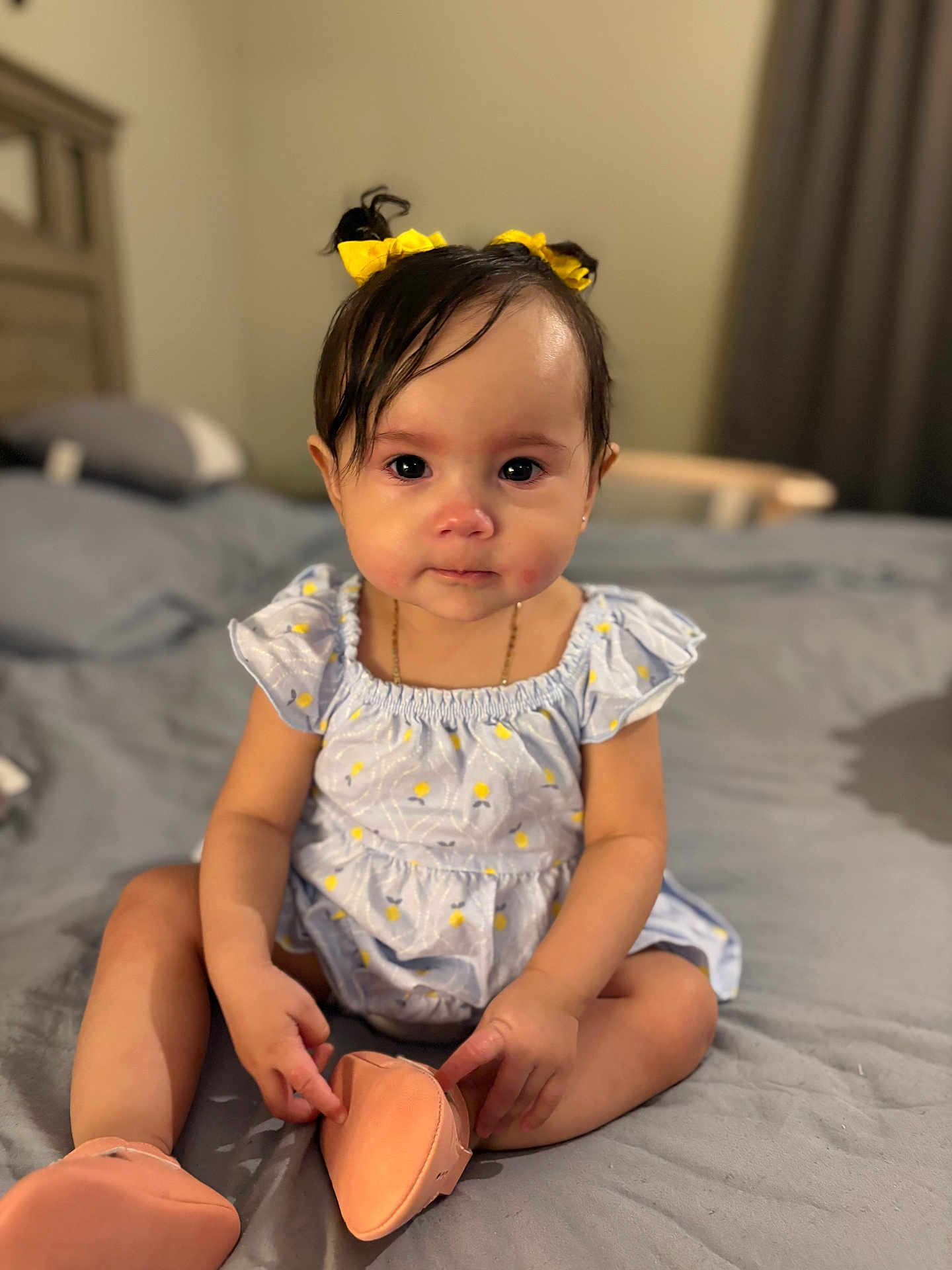 Alora is registered to the contest to win money with this photo: baby, child, girl, yellow_hair_bows, dress, shoes, bed, bedroom, curly_hair, sitting, indoors, cute, infant, person, furniture, soft_lighting, portrait, young_child, human, apparel