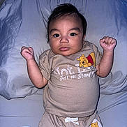 Damian joined the competition — help win amazing prizes! baby, infant, child, pillow, bed, clothing, tshirt, shorts, winnie_the_pooh, cute, indoors, portrait, smiling, arms_raised, blanket, sleepwear, face, person, lying_down, soft_fabric