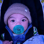 Damian joined the competition — help win amazing prizes! baby, pacifier, hat, knit_hat, denim_overalls, blanket, star_pattern, child, infant, closeup, face, eyes, cute, cozy, warm_clothing, portrait, car_seat, straps, indoor, soft_texture