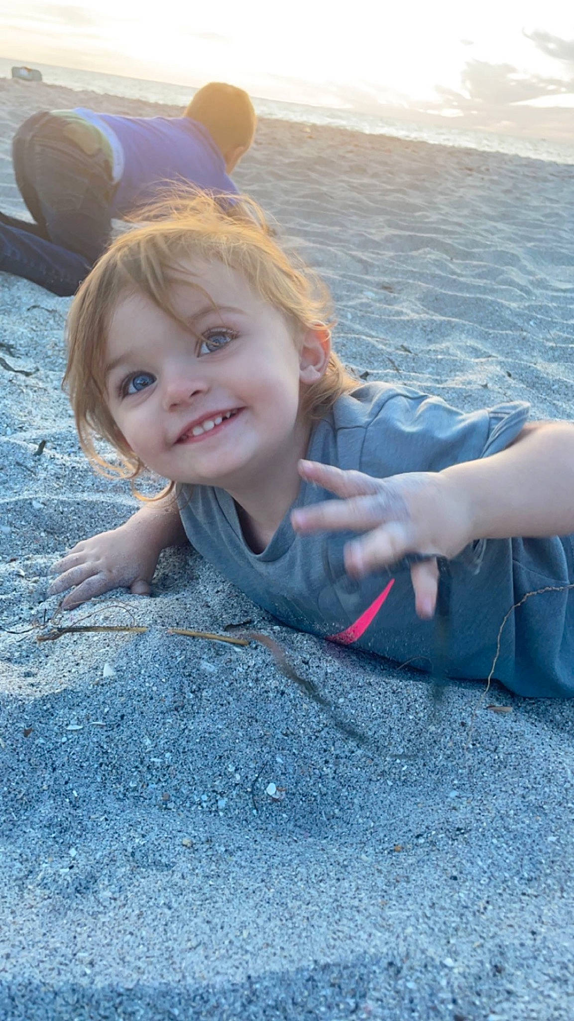 Ridley is registered to the contest to win money with this photo: asphalt, beach, body_of_water, electric_blue, eye, fun, gesture, happy, head, joy, leisure, light, people, people_in_nature, person, road_surface, sand, smile, summer, sunlight