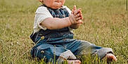 Walker joined the competition — help win amazing prizes! baby, barefoot, casual_clothing, child, clapping, curly_hair, cute, daylight, field, grass, greenery, happy, nature, outdoor, overalls, portrait, sitting, smile, toddler, young_child