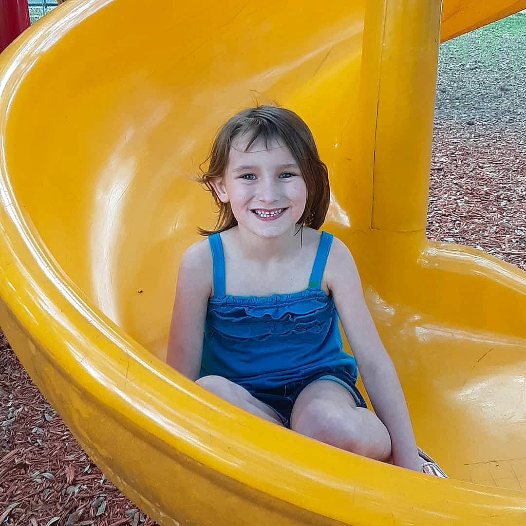 Kaylyn is registered to the contest to win money with this photo: child, chute, fun, joy, leisure, outdoor_play_equipment, person, play, playground, playground_slide, recreation, smile, yellow