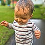 child, toddler, wet_hair, striped_shirt, dirt, outdoor, garden, greenery, path, exploring, happy, cute, nature, person, smiling, dirty_hands, fun, playful, casual_clothing, daylight