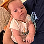 baby, infant, child, person, arms, clothing, pacifier, giraffe, shirt, indoor, carpet, hand, face, cute, skin, holding, people, young, newborn, comfort