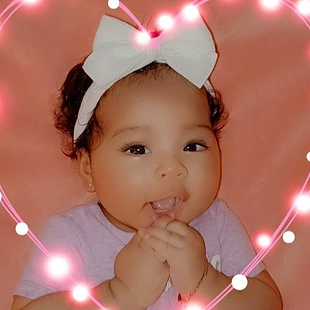 Nye is registered to the contest to win money with this photo: baby, beauty, cheek, ear, event, eyebrow, eyelash, finger, flash_photography, gesture, happy, head, headband, headpiece, light, lighting, lip, person, pink, toddler