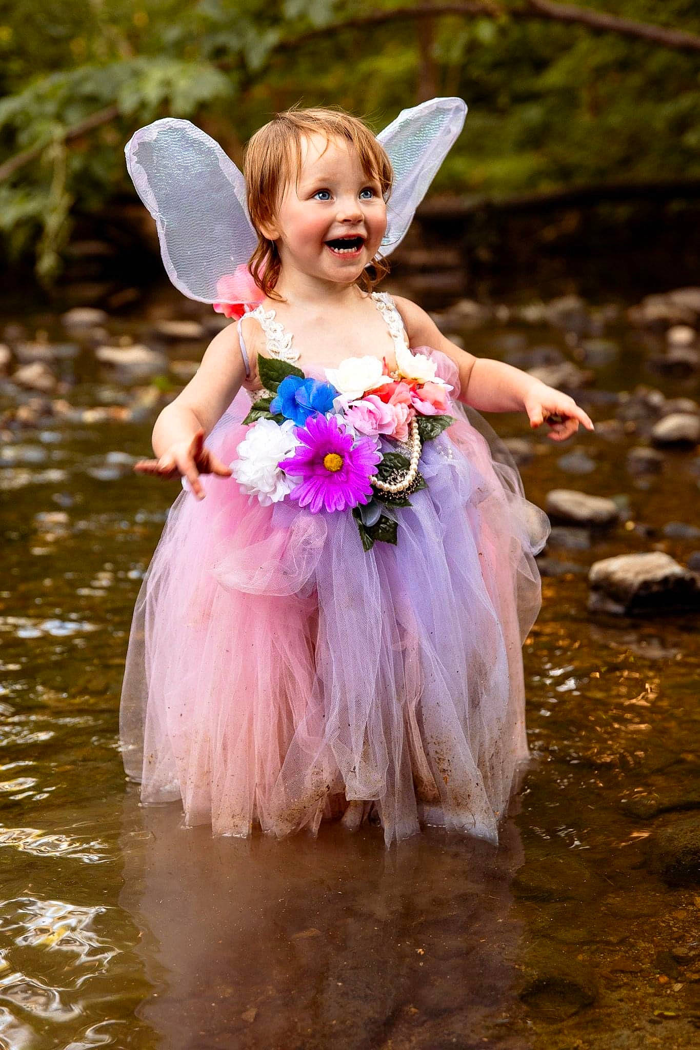 Thea is registered to the contest to win money with this photo: angel, child, event, flower, fun, gown, grass, happy, headpiece, joy, lake, leisure, magenta, mythical_creature, people_in_nature, person, petal, pink, plant, smile