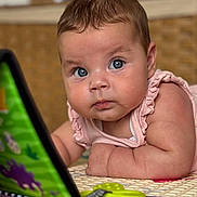 Selena participe au concours pour gagner de l'argent avec cette photo : baby, blue_eyes, curious, play_mat, toy_book, indoor, close_up, infant, child, colorful, soft_lighting, face, skin, arm, clothing, pink_outfit, expression, young_child, focus, floor