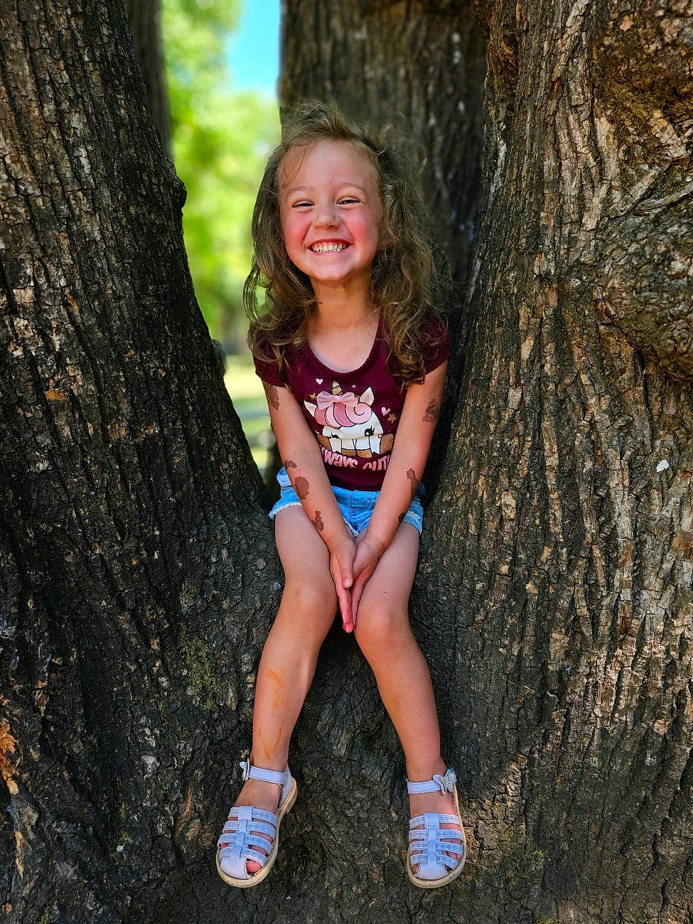 Lila is registered to the contest to win money with this photo: branch, eye, facial_expression, flash_photography, grass, happy, head, human_body, joy, leaf, people_in_nature, person, plant, smile, standing, summer, thigh, tree, trunk, wood