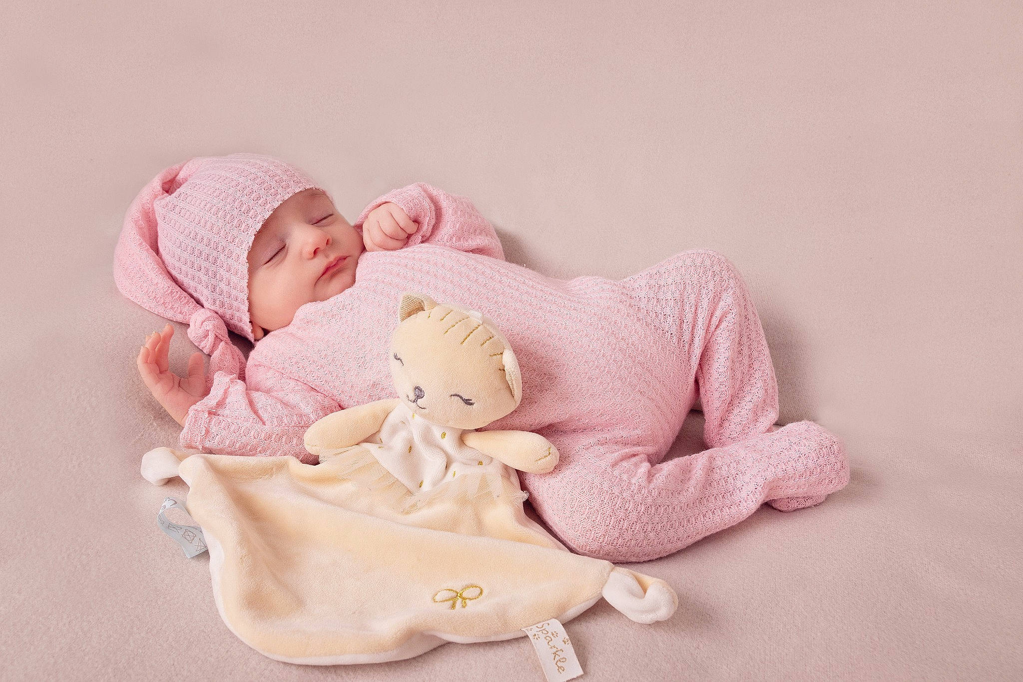 Lisa participe au concours pour gagner de l'argent avec cette photo : arm, baby, baby_products, baby_sleeping, baby_toddler_clothing, child, comfort, face, foot, happy, hat, headwear, human_leg, linens, magenta, person, pink, sitting, skin, sleeve