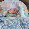 newborn, baby, infant, blanket, hat, striped, baby_seat, cushion, polka_dot, sleepwear, cozy, indoors, child, face, clothing, resting, cute, soft, striped_blanket, young