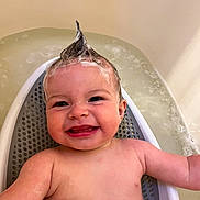 Finn is registered to the contest to win money with this photo: baby, child, bath, bathtub, water, smile, happy, shampoo, hair, mohawk, skin, arm, face, infant, playful, cute, joy, sitting, bathseat, foam