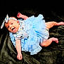 adorable, baby, blue_dress, child, cute, expressive_face, happy, headband, indoors, infant, joyful, lying_down, one_person, playful, portrait, small_feet, small_hands, smiling, soft_blanket, tutu