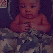 Luciousrowan is registered to the contest to win money with this photo: baby, child, blanket, car_seat, camouflage, clothing, face, hands, indoor, infant, looking, person, portrait, seat, sitting, soft, toddler, young_child, warning_label, young
