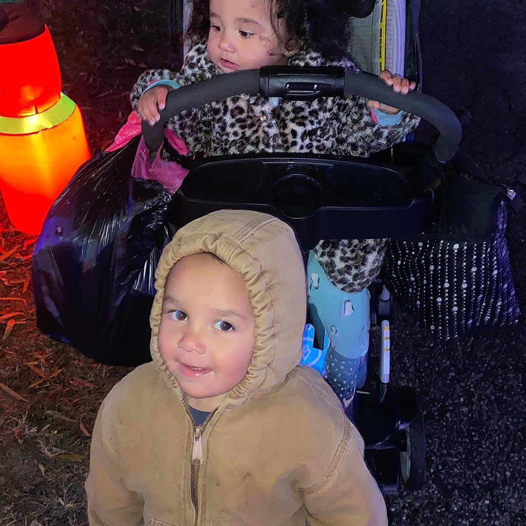 Luciousrowan is registered to the contest to win money with this photo: card, child, curly_hair, cute, family, festive, grass, hooded_jacket, inflatable_decoration, leopard_print, night, outdoor, pavement, playful, shoes, smile, stroller, toddler, toy, winter_clothing