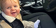 Arthur is registered to the contest to win money with this photo: baby, child, smile, car_interior, seat, clothing, vest, beige, black, sock, happy, person, portrait, steering_wheel, bmw_logo, car_seat, window, door, gear_shift, casual