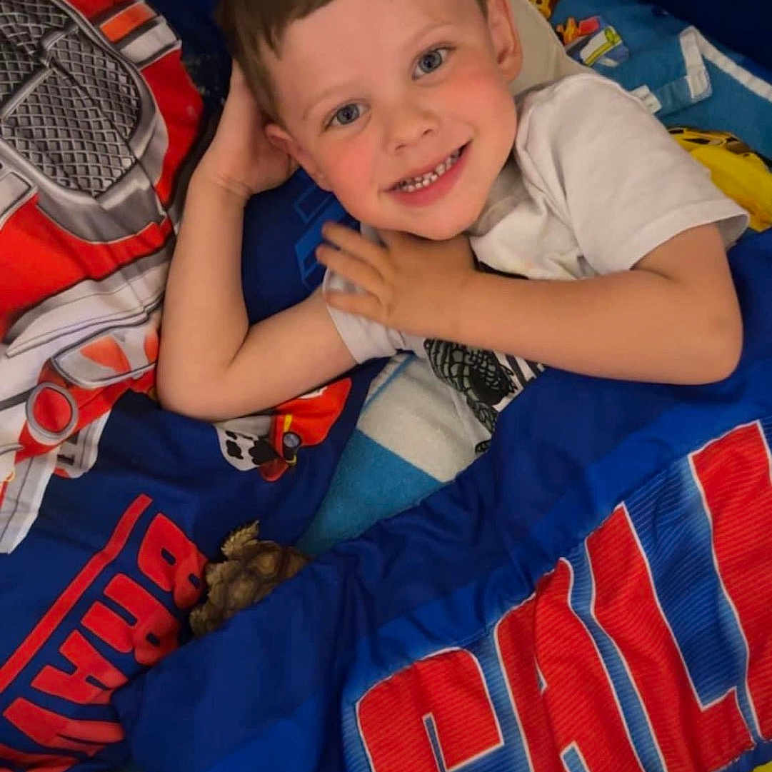 Oliver is registered to the contest to win money with this photo: baby, ball, blanket, clothing, cushion, face, football, furniture, happy, head, homedecor, person, photography, portrait, quilt, smile, soccer, soccerball, sport, t_shirt