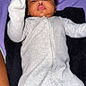Kamari is registered to the contest to win money with this photo: arm, baby, blanket, child, closeup, curious, fabric, face, gray_clothing, hand, head, indoor, infant, lying_down, onesie, person, portrait, purple_blanket, skin, sleepy