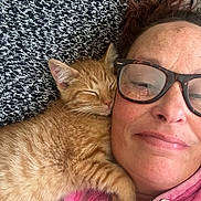 Cheeto joined the competition — help win amazing prizes! cat, closeup, comfort, cozy, cute, face, glasses, hug, indoor, kitten, orange_tabby, pet, pink_hoodie, portrait, relaxation, resting, sleeping, snuggle, texture, woman