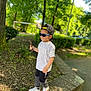 Adriano participe au concours pour gagner de l'argent avec cette photo : boy, cap, casual_clothing, child, confident, fashion, greenery, leisure, nature, outdoor, park, playful, shadow, sidewalk, stick, sunglasses, sunlight, trees, white_shoes, young
