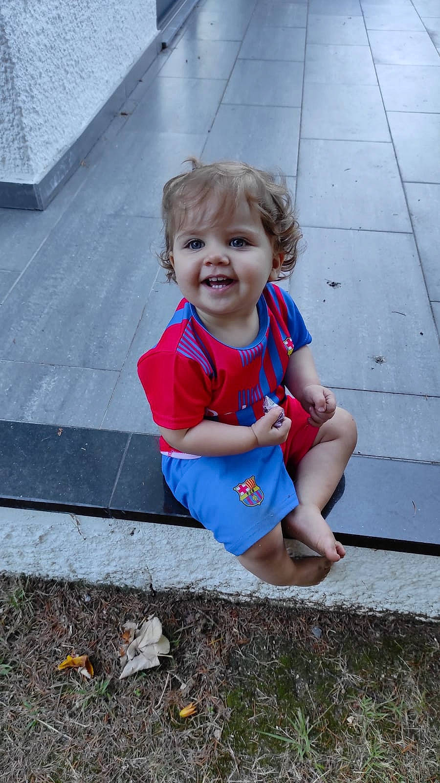 Violeta a rejoint le concours — aidez-le/la à gagner de superbes lots ! asphalt, baby_toddler_clothing, child, electric_blue, eye, face, flooring, fun, grass, hand, happy, joy, leisure, people_in_nature, person, road_surface, sidewalk, sitting, smile, t_shirt