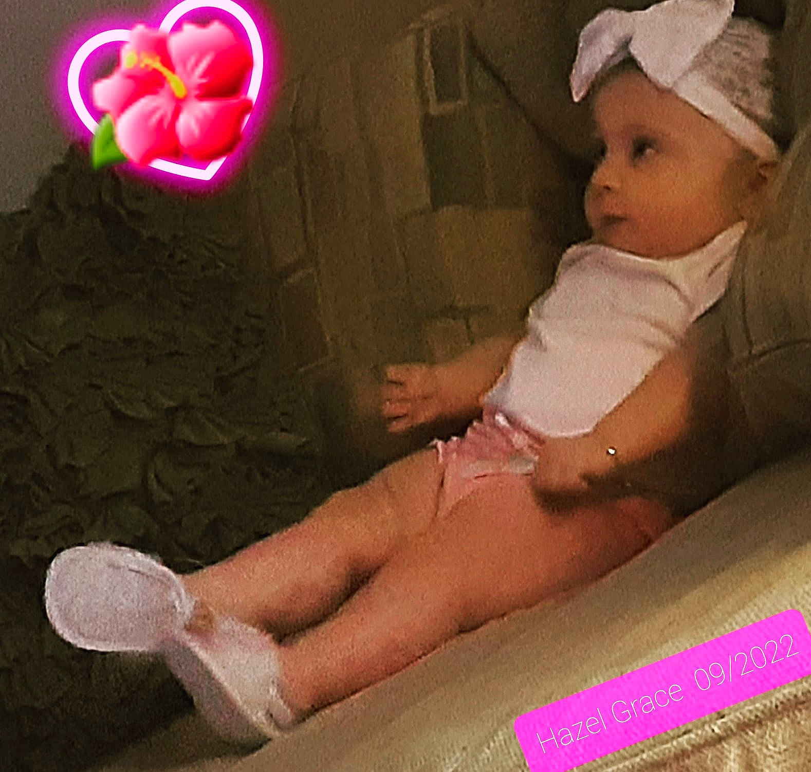Hazel Grace is registered to the contest to win money with this photo: arm, baby, baby_toddler_clothing, cap, comfort, finger, flower, foot, gesture, human_leg, knee, lap, magenta, nail, person, petal, pink, rose, sitting, thigh