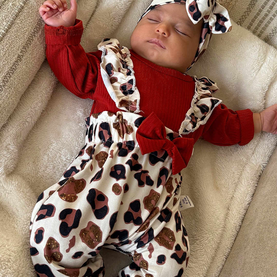 Hélyana participe au concours pour gagner de l'argent avec cette photo : baby, blanket, bow, child, clothing, couch, cozy, cute, fabric, headband, indoors, infant, leopard_print, patterned, peaceful, pillow, resting, sleeping, socks, soft_texture