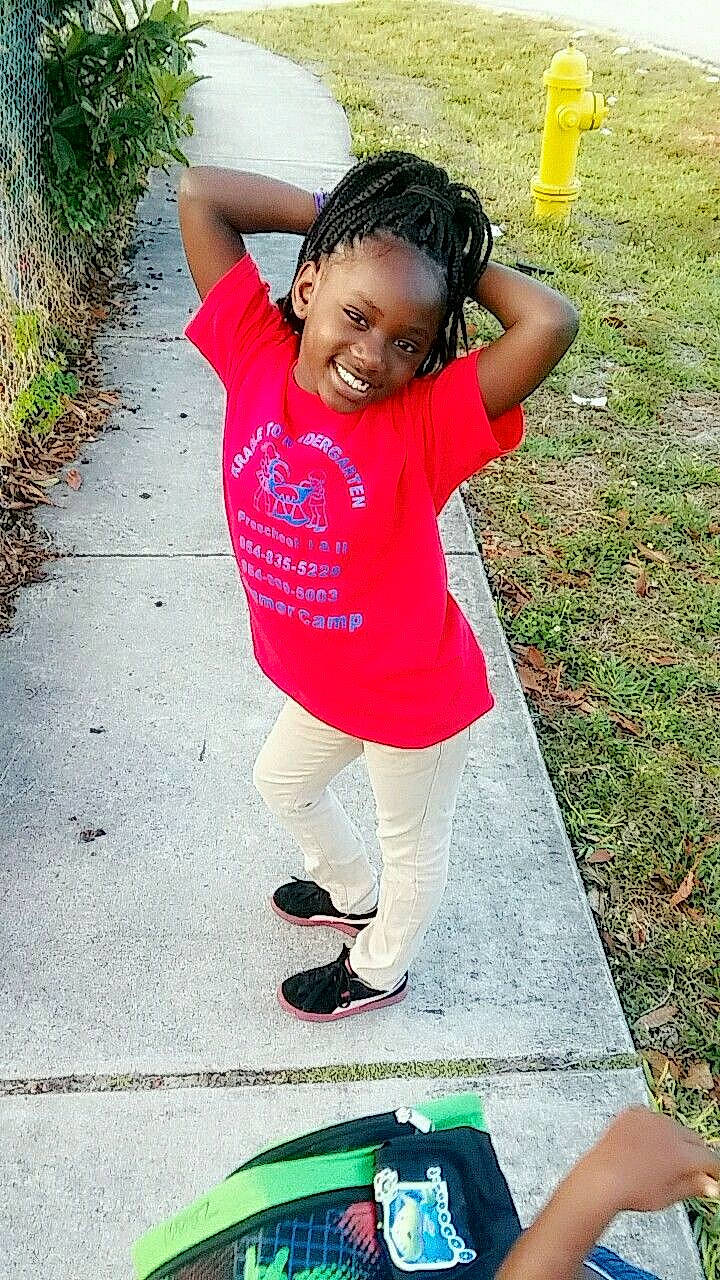 Zaniyah joined the competition — help win amazing prizes! black_hair, child, cool, day, fun, girl, grass, green, joy, leisure, person, pink, play, recreation, red, shoulder, sitting, smile, standing, summer