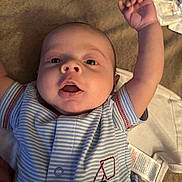 Kaine joined the competition — help win amazing prizes! baby, infant, child, onesie, clothing, blue_stripes, arm_raised, face, mouth_open, lying_down, soft_surface, diaper, tag, cute, expression, human, skin, person, young, playful