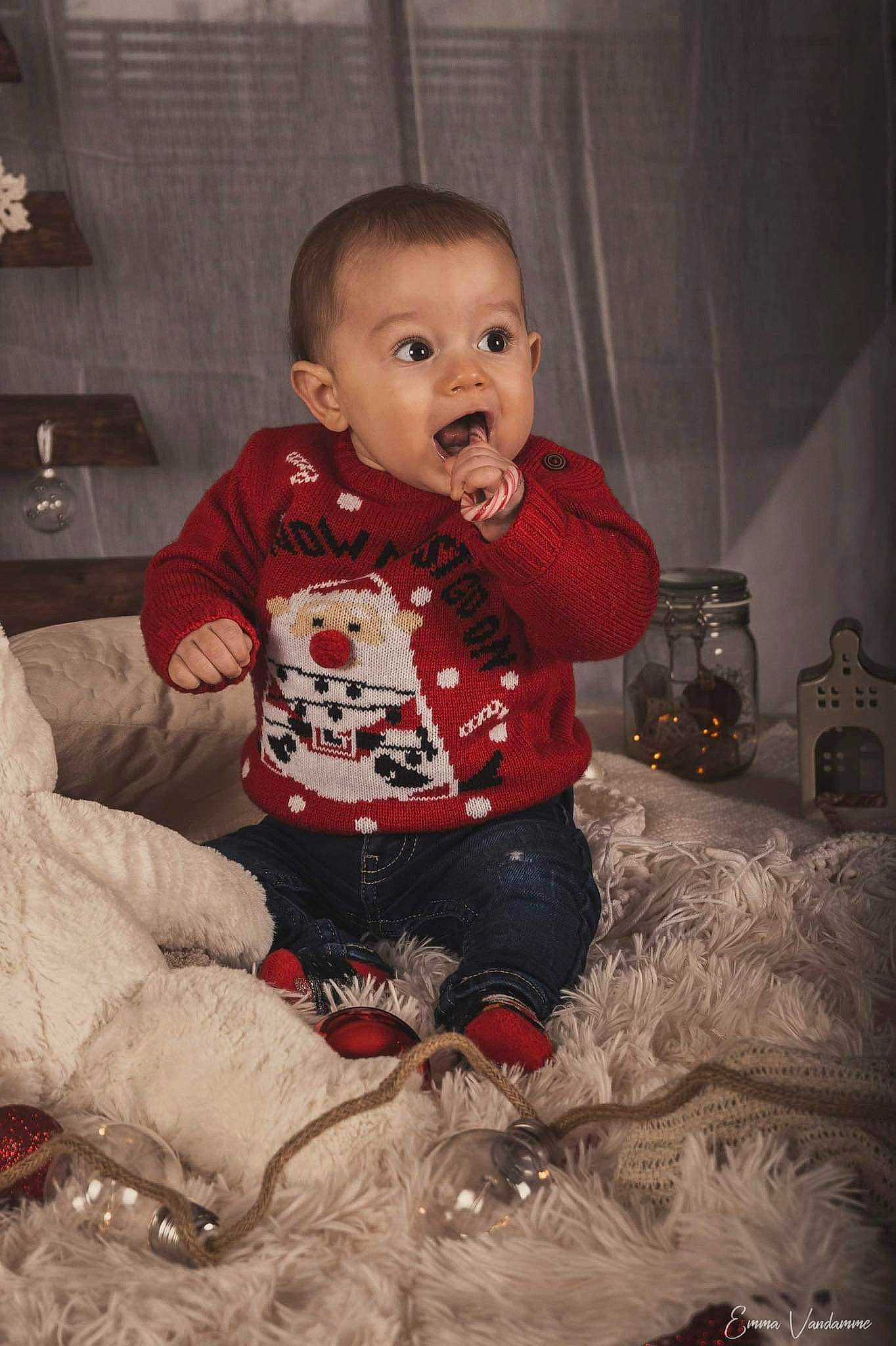 Mateo participe au concours pour gagner de l'argent avec cette photo : baby, baby_toddler_clothing, carmine, cheek, child, christmas, comfort, event, face, flooring, fun, happy, head, holiday, lap, person, room, sitting, sleeve, surprise