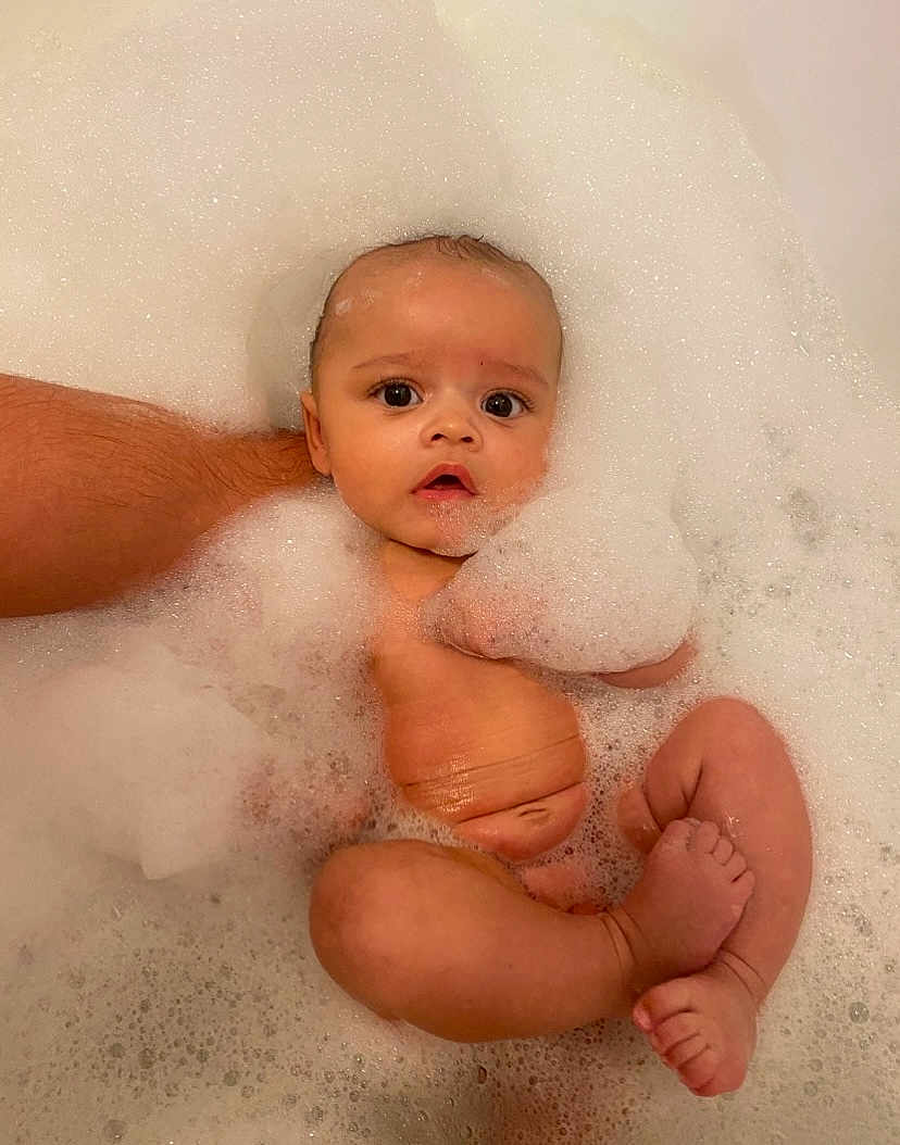 Oakley is registered to the contest to win money with this photo: baby, bath, bubbles, foam, water, infant, child, skin, arm, foot, toes, hand, relaxation, cleaning, bathroom, cute, young, sitting, support, person