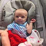 Alora joined the competition — help win amazing prizes! baby, infant, smile, face, blanket, bib, red_skirt, baby_seat, cushion, clothing, foot, hand, cute, portrait, indoor, soft_toy, comfort, happy, newborn, resting