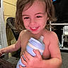 blanket, cartoon, casual, child, cute, diaper, expression, face, furniture, hair, hand, happy, indoor, plastic_cup, porch, sippy_cup, sitting, smiling, toddler, young_child