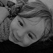 Hartley joined the competition — help win amazing prizes! child, smiling, face, blanket, pattern, hair, lying_down, cozy, black_and_white, portrait, indoors, close_up, cute, warm, soft_texture, young, happy, resting, casual, relaxed
