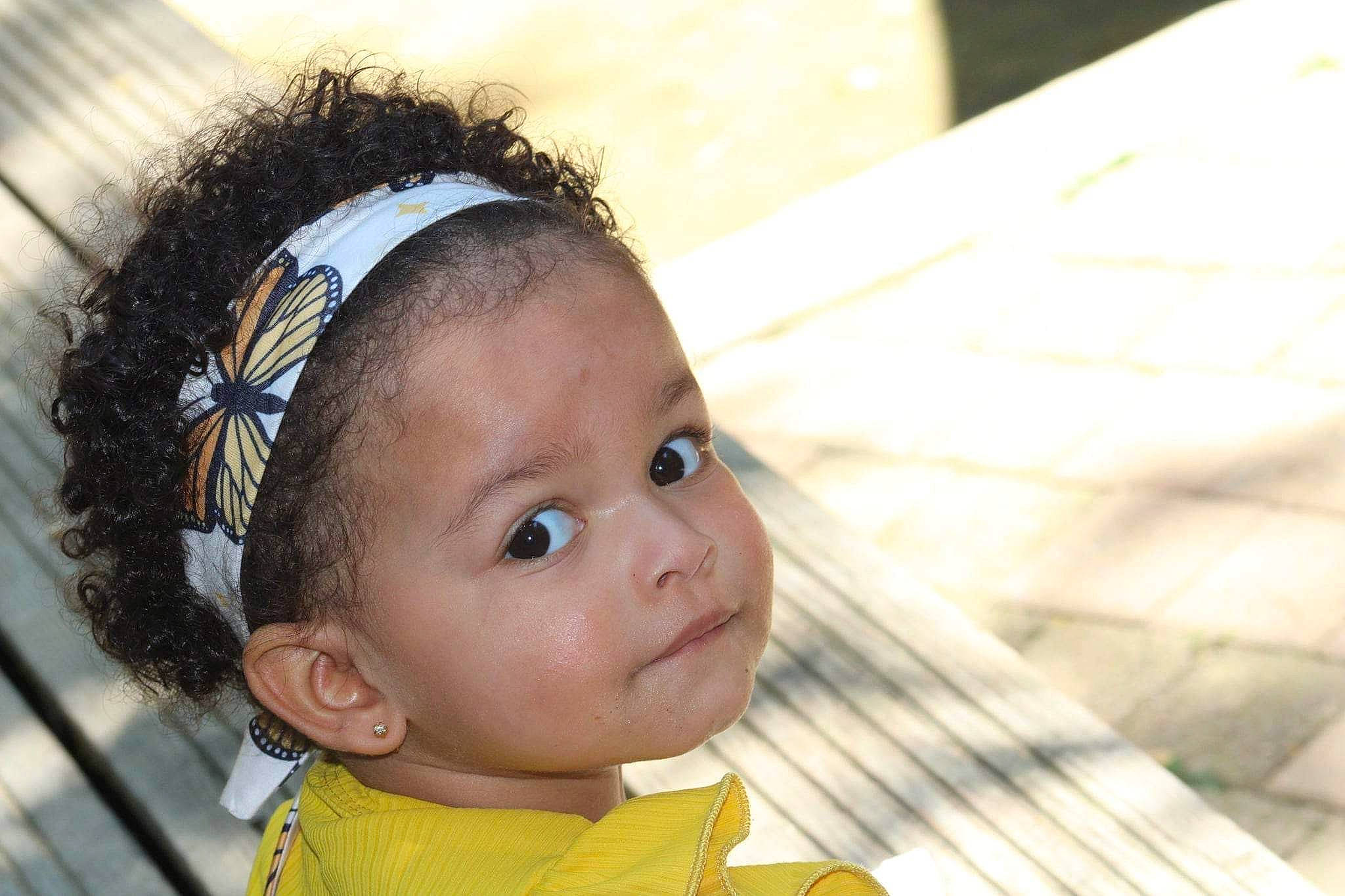 Yüna participe au concours pour gagner de l'argent avec cette photo : audio_equipment, baby, baby_toddler_clothing, black_hair, cheek, child, ear, eye, eyelash, fashion_accessory, hair, hair_accessory, hairstyle, happy, head, headband, headpiece, hearing, iris, person