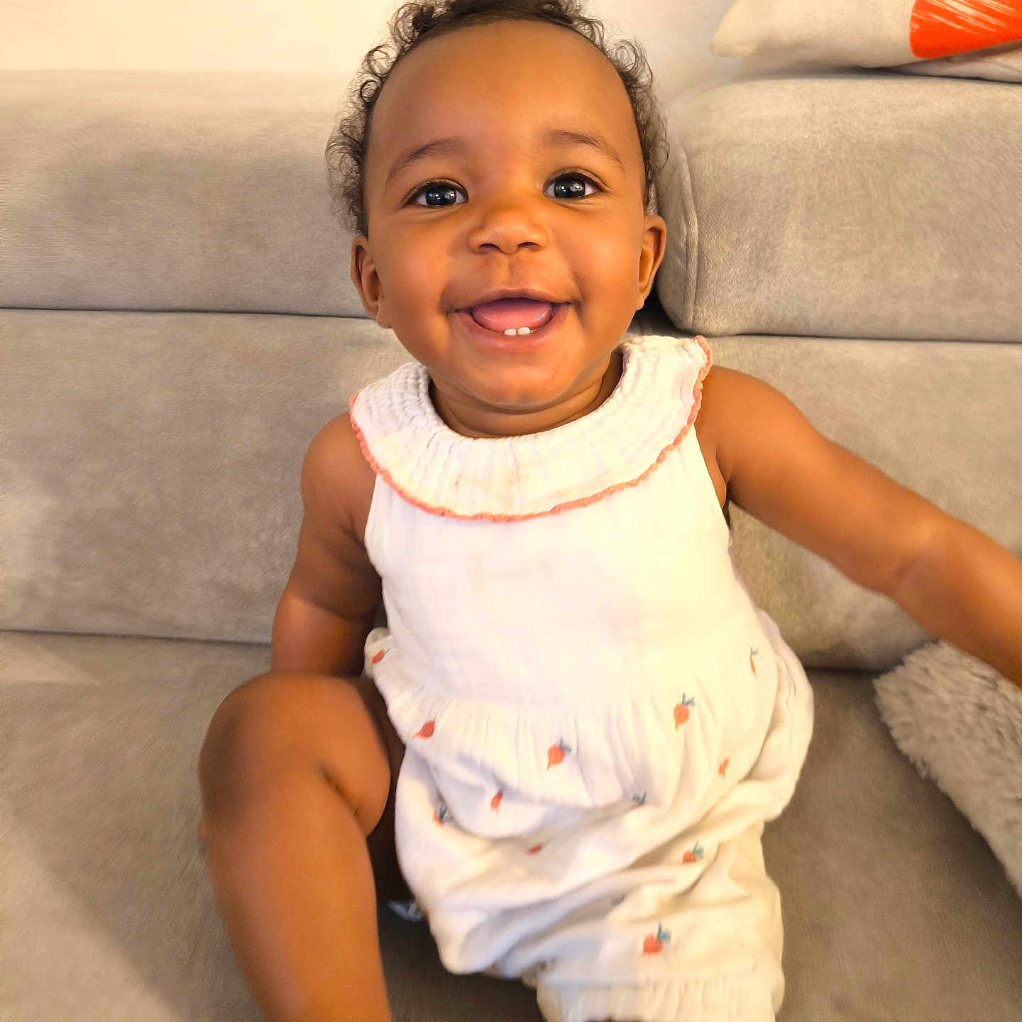 Mayvis a rejoint le concours — aidez-le/la à gagner de superbes lots ! baby, child, couch, curly_hair, cute, fabric, face, happy, home, indoor, infant, one_person, pacifier, pillow, portrait, sitting, skin, smile, white_outfit, young_child