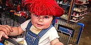Starla joined the competition — help win amazing prizes! baby, blue_eyes, child, cute, denim_overall, face, hand, hat, indoor, infant, person, red_feathers, retail, shelves, shopping, shopping_cart, store, tattoo, toys, white_shirt