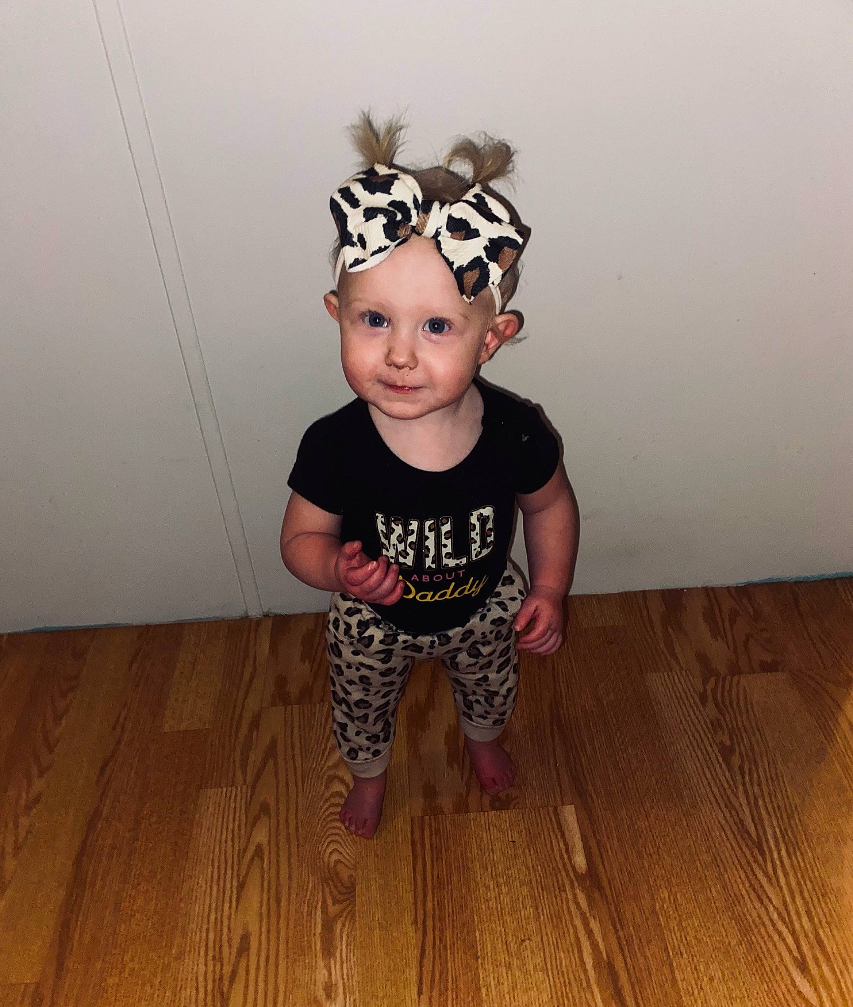 Daisy is registered to the contest to win money with this photo: baby, baby_toddler_clothing, face, fashion_accessory, floor, flooring, happy, hardwood, head, headband, headpiece, headwear, laminate_flooring, pattern, person, personal_protective_equipment, sleeve, t_shirt, toddler, wood