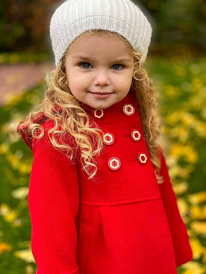 Emma participe au concours pour gagner de l'argent avec cette photo : cap, dress, eye, face, grass, hair, happy, head, headwear, human_body, iris, joy, lip, outerwear, people_in_nature, person, pink, plant, red, skin