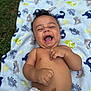 baby, infant, laughing, smiling, diaper, blanket, dinosaur_pattern, outdoor, grass, happy, cute, child, toddler, skin, bare_chest, playful, joyful, portrait, infancy, nature
