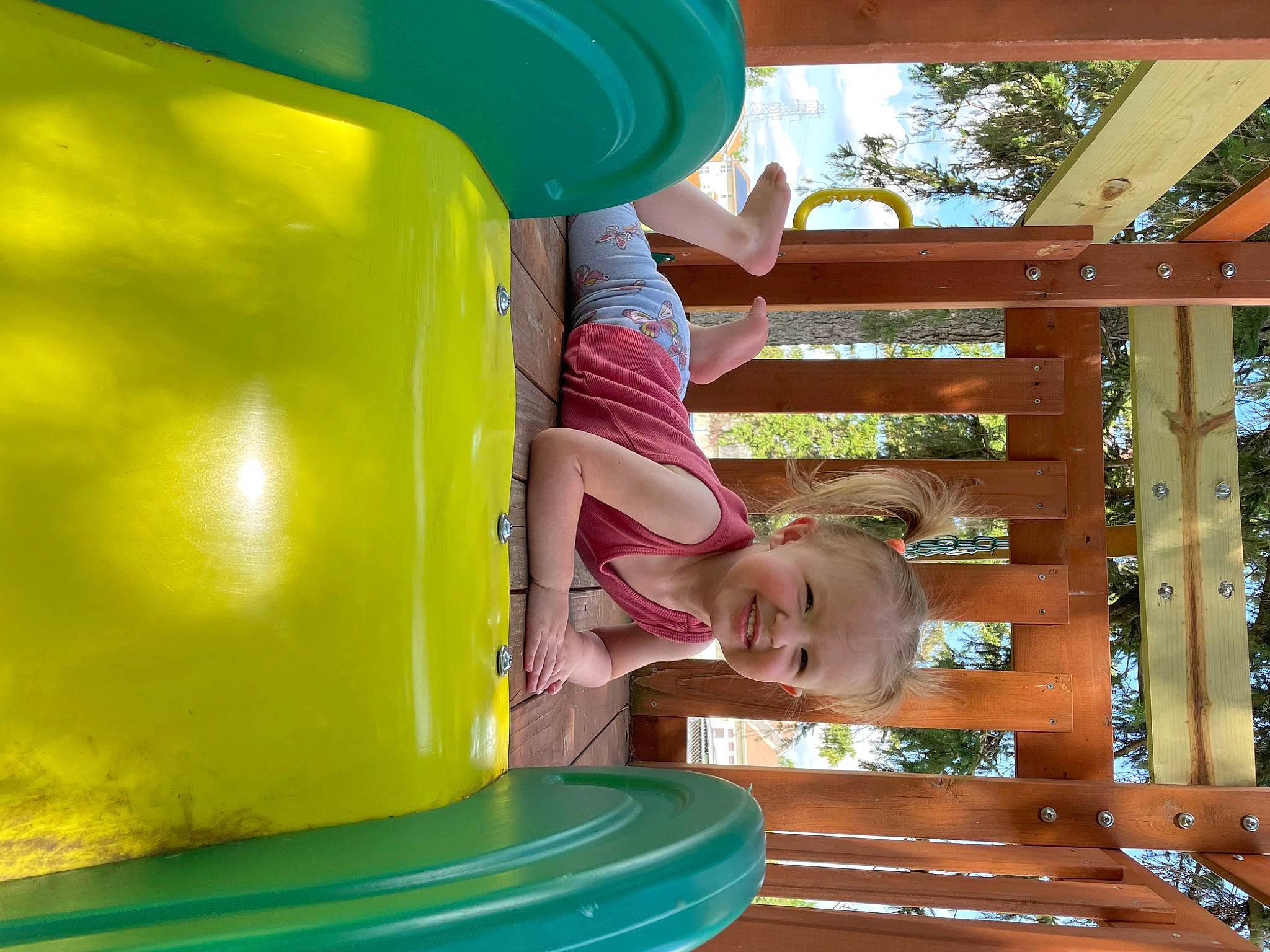 Alivia is registered to the contest to win money with this photo: baby_toddler_clothing, child, chute, city, fun, green, happy, joy, leisure, magenta, outdoor_play_equipment, person, plant, plastic, play, playground, playground_slide, recreation, smile, toddler