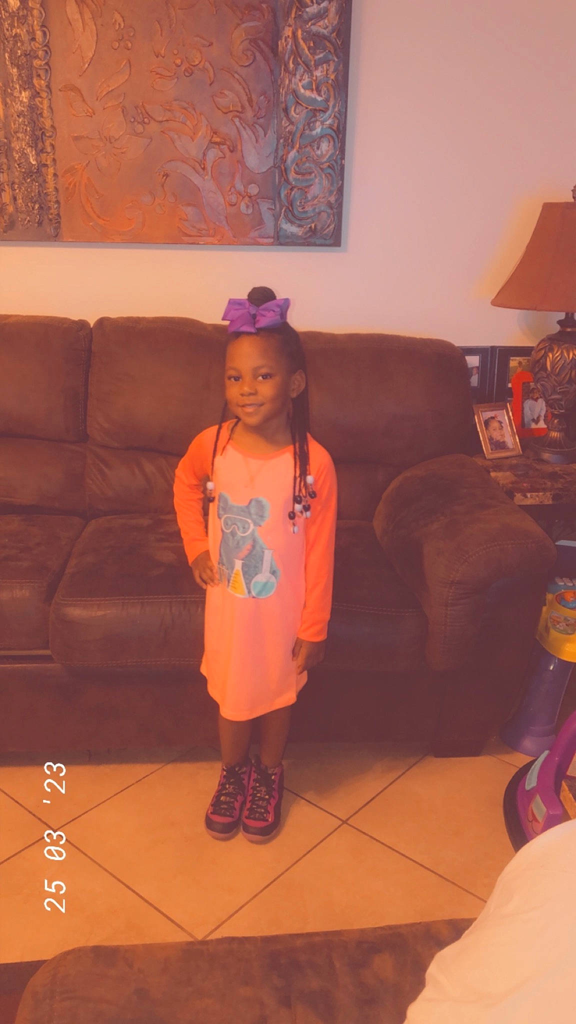 Jakaylyn joined the competition — help win amazing prizes! child, comfort, couch, eye, face, floor, flooring, fun, hat, joy, lamp, living_room, orange, person, picture_frame, purple, room, sitting, smile, t_shirt