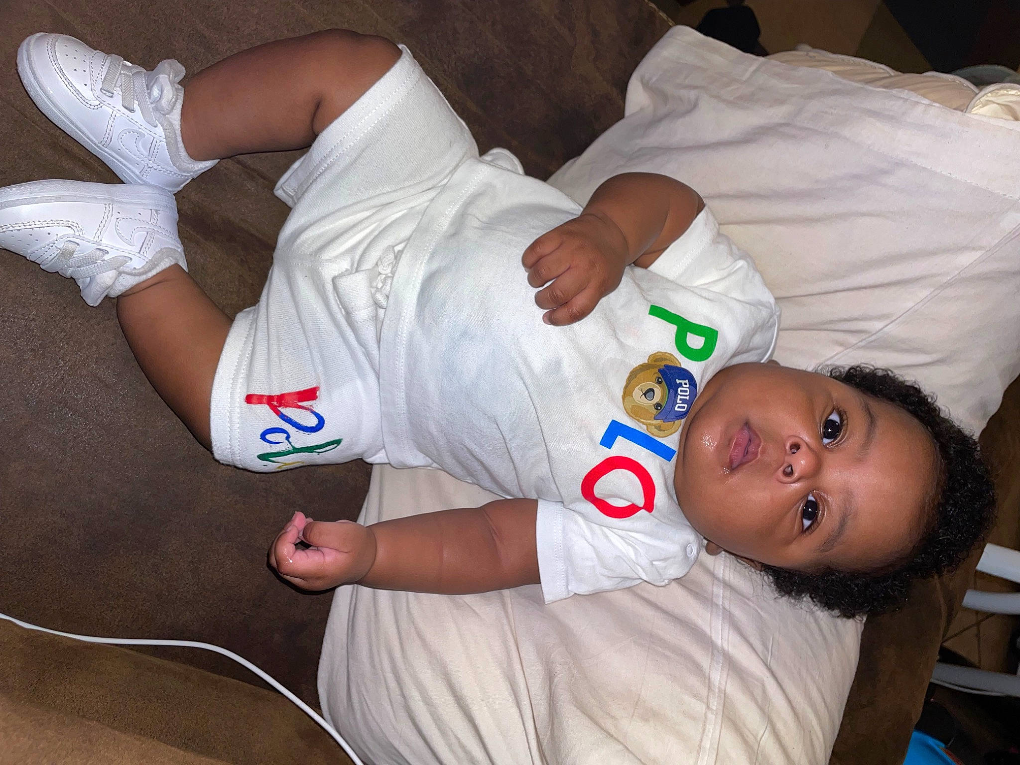 Bro Drick is registered to the contest to win money with this photo: baby, baby_products, baby_toddler_clothing, carmine, child, comfort, elbow, finger, gesture, human_leg, joint, knee, mouth, person, sleeve, t_shirt, thigh, thumb, toddler, white