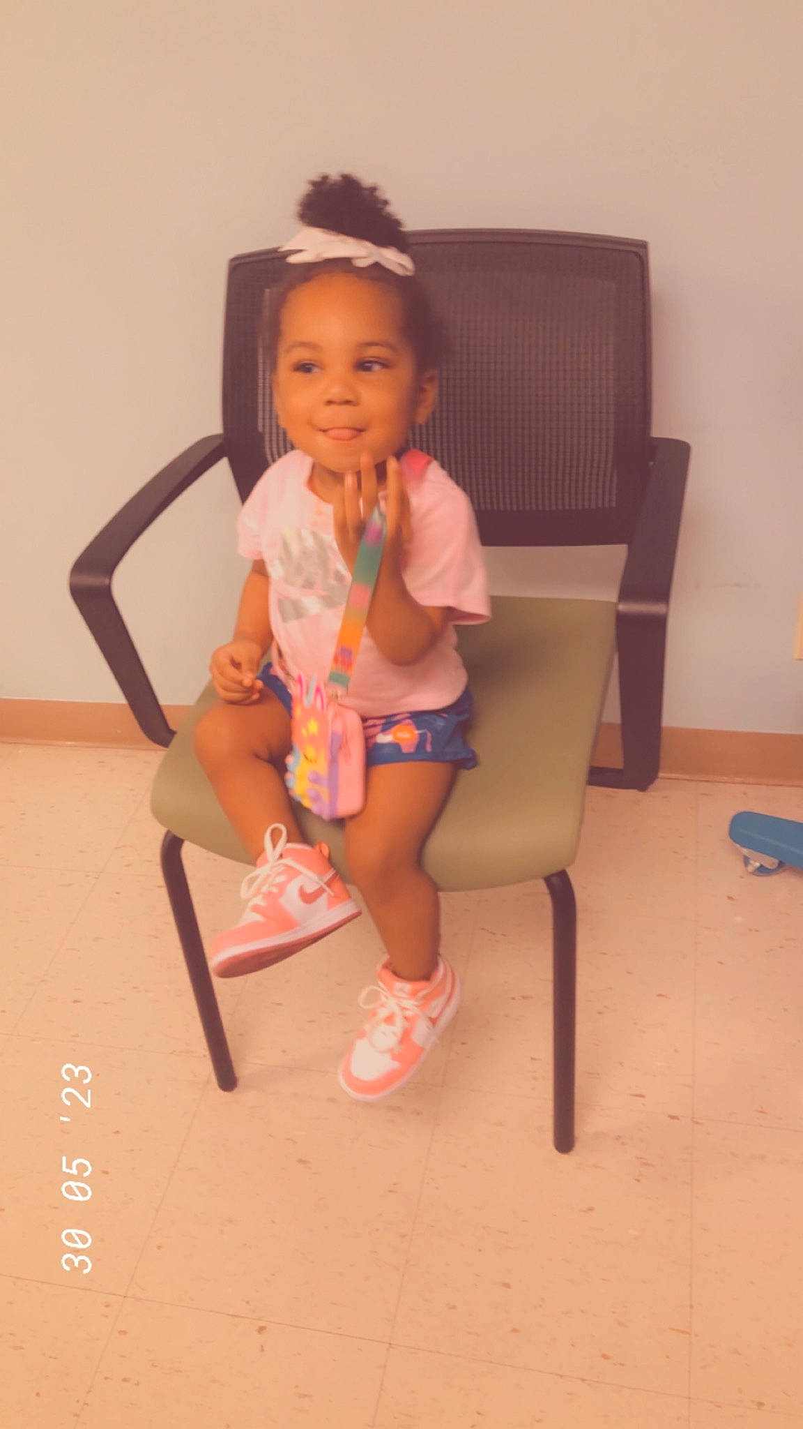 Avaughni is registered to the contest to win money with this photo: baby_toddler_clothing, chair, child, flooring, foot, fun, happy, human_leg, joy, knee, leg, magenta, person, room, sandal, shorts, sitting, smile, sock, thigh