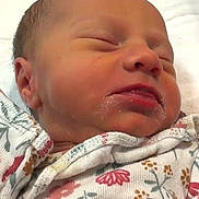 Gabriella joined the competition — help win amazing prizes! baby, blanket, child, closeup, cozy, cute, face, floral_pattern, indoors, infant, newborn, onesie, peaceful, portrait, resting, skin, sleeping, soft, tiny, wrapped